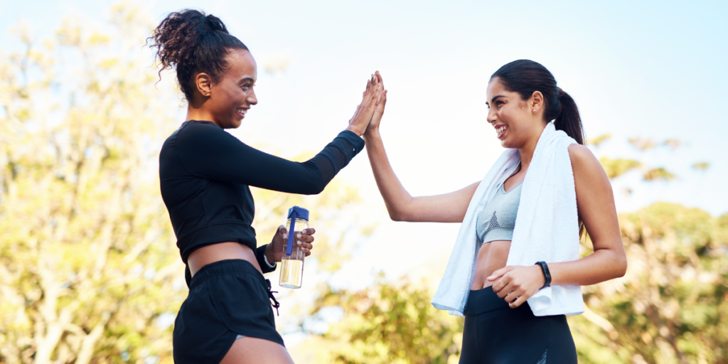 Two women celebrating after outdoor exercise to support winter health and wellbeing.